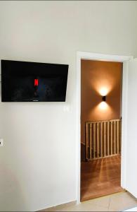telewizor z płaskim ekranem na ścianie pokoju w obiekcie Mimosa House w mieście Gythio