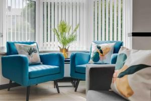 een woonkamer met twee blauwe stoelen en een bank bij Orange Rentals- 3 bed Scouse House Sleeps up to 8 guests in Liverpool