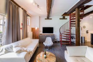 uma sala de estar com um sofá branco e uma escada em Meschermolen 3 em Withuis
