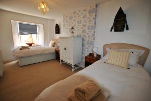 a bedroom with two beds and a window at Heron Cottage- fishermans cottage by the sea in Anstruther