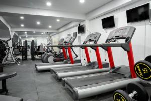 a gym with rows of tread machines in a room at Bloom Hotel in Baghdad