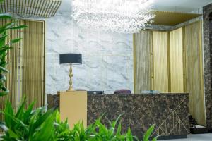 a lobby with a reception desk and a chandelier at Bloom Hotel in Baghdad