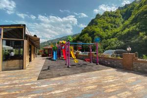 a playground with colorful equipment in front of a building at Kackarsan Vip wooden Suites in Rize
