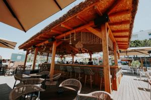 a restaurant with tables and chairs and a bar at Martiness Hotel Durres in Durrës