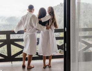 亞列姆切的住宿－Ведмежа гора Panorama Spa Resort，站在窗前的男人和女人