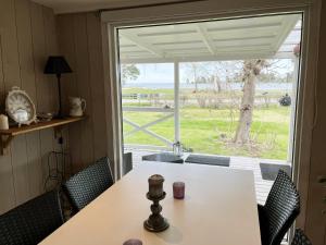 mesa y sillas en una habitación con ventana en Nice holiday home in Skappevik with sea view en Bergkvara