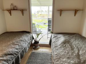 2 camas en una habitación con ventana en Nice holiday home in Skappevik with sea view en Bergkvara
