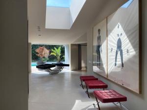 Boomerang House - Luxury House next to City Park في بورتو: غرفة معيشة مع مقاعد حمراء ومسبح