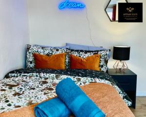 Schlafzimmer mit einem Bett mit orangefarbenen und blauen Kissen in der Unterkunft Stunning Tropical Oasis By Artisan Stays I Free Parking I Sleeps 7 in Southend-on-Sea