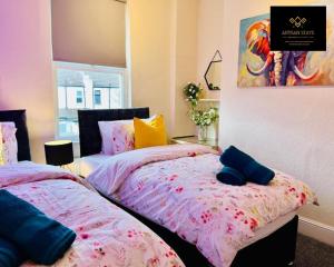 1 dormitorio con 2 camas y un cuadro en la pared en Stunning Tropical Oasis By Artisan Stays I Free Parking I Long-stay Offer I Relocation or Business, en Southend-on-Sea