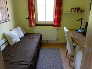 a bedroom with a bed and a desk and a window at Ferienhaus "Op'n Barg" in Holzbunge