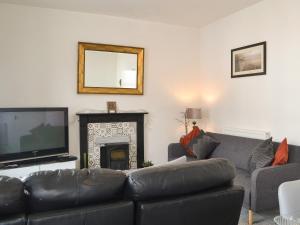 Il comprend un salon doté d'un canapé, d'une télévision et d'une cheminée. dans l'établissement Harbour View - Uk44164, à Bridlington