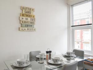 d'une salle à manger avec une table, des chaises et une fenêtre. dans l'établissement Harbour View - Uk44164, à Bridlington