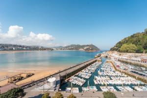 a view of a beach and a dock with boats at Lasala Plaza Hotel in San Sebastián