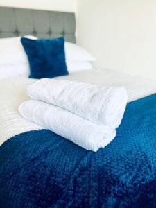 une pile de serviettes blanches assises sur un lit dans l'établissement HU-Thirteen Loft Duplex Studio- Sleeps 2, à Hull