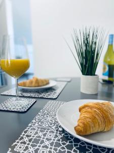 a table with a plate of bread and a glass of orange juice at HU-Thirteen Loft Duplex Studio- Sleeps 2 in Hull