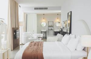 a bedroom with a white bed and a living room at Sundance Dayclub Hua Hin in Hua Hin