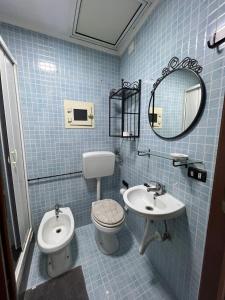 een blauw betegelde badkamer met een toilet en een wastafel bij Casa vacanza Da Totore in Napels