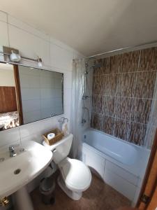a bathroom with a toilet and a sink and a tub at La Casa Vinilla in Casablanca