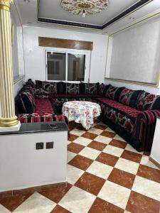 a living room with a couch and a checkered floor at GHIZLAN apartment TETOUAN in Tétouan