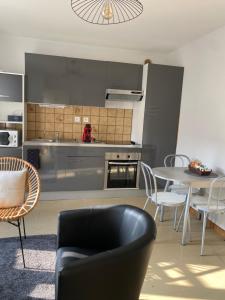 una cucina con divano, tavolo e sedie di Confortable et agréable T1 n•1 a Ussel