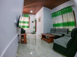 a living room with two couches and a table at Nature Springs Belihul oya in Balangoda