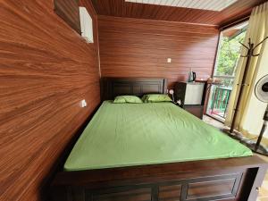 um quarto com uma cama numa parede de madeira em Nature Springs Belihul oya em Balangoda