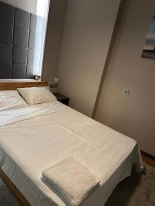 Lux apartments Top center في صوفيا: سرير أبيض كبير في غرفة مع نافذة