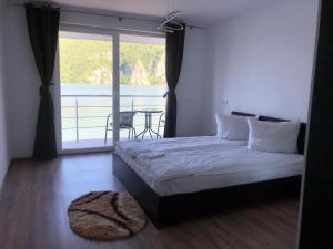 een slaapkamer met een bed en een balkon met een tafel bij Casa Adrian in Eşelniţa