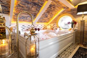 Andalouse Elegant Suite Hotel في طرابزون: حوض استحمام في غرفة مع سقف