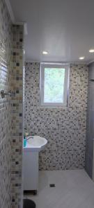 La salle de bains est pourvue d'un lavabo et d'une fenêtre. dans l'établissement Guest House Krasi, à Ovoshtnik