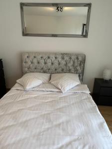 Una cama en un dormitorio con un espejo encima. en I&M Apartments Sikorskiego Wrocław, en Wroclaw