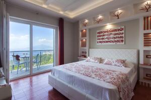 a bedroom with a large bed and a large window at Villa Prestige in Sorrento