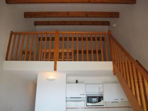 a staircase in a room with a microwave and a kitchen at Appartement lumineux avec VUE MER pour 6 personnes in Valras-Plage