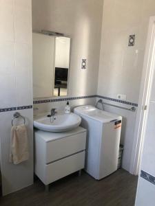 La salle de bains blanche est pourvue d'un lavabo et d'un miroir. dans l'établissement Spacious 1 bedroom apartment, Nerja centre 3i, à Nerja