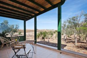 a porch with a table and chairs and a view of the desert at La Finca Las Estrellas in Tarajalejo