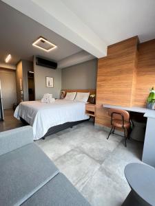 Cette chambre comprend un lit, un bureau et une table. dans l'établissement Studio Apartamento - Bela Vista São Paulo Centro, à São Paulo