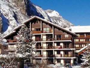 a building with a christmas tree in front of a mountain at Studio Valloire, 1 pièce, 4 personnes - FR-1-263-19 in Valloire