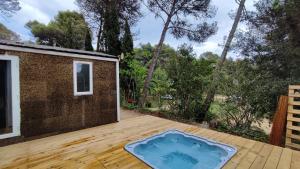 una bañera de hidromasaje en una terraza de madera con una casa en Camping Santa Elena, en Lloret de Mar