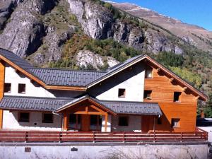a large wooden cabin with a mountain in the background at Appartement Valloire, 4 pièces, 8 personnes - FR-1-263-209 in Valloire
