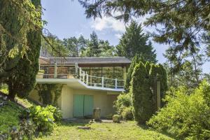 una casa con una puerta verde en un patio en Eure95KM PARIS JO prés Giverny et Macarthur piscine intérieure chauffee, en Chambray