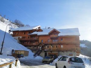 a large wooden building with cars parked in the snow at Appartement Valloire, 3 pièces, 5 personnes - FR-1-263-224 in Valloire