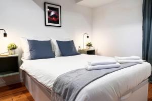 een slaapkamer met een groot wit bed met blauwe kussens bij El Mar de Casa en Cudillero by Batuecas in Cudillero
