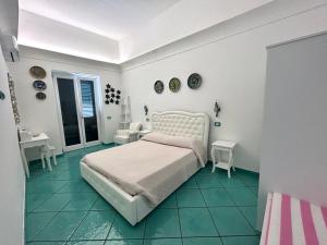 アマルフィにあるTENUTA CAVALIERE Breathtaking viewの緑のタイルフロアのベッドルーム1室(白いベッド1台付)