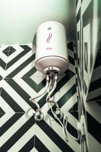 a blow dryer in a bathroom with a black and white floor at Pachamama Hostel in Jaipur