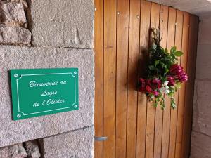 Un cartello su un muro con un mazzo di fiori di Logis de l'Olivier ad Asnières-sur-Nouère
