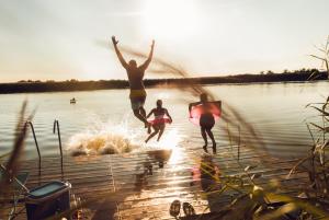 three people jumping into the water on a lake at Weitblick Winterberg in Winterberg