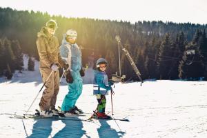 two adults and a child on skis in the snow at Weitblick Winterberg in Winterberg