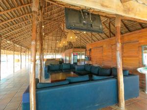 a living room with a blue couch and a tv at The Cove Pasikuda - Eco Resort in Pasikuda