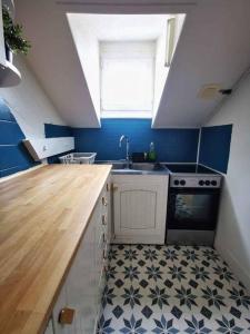 a kitchen with a sink and a stove at Bel Appartement 10mn PARIS in Argenteuil
